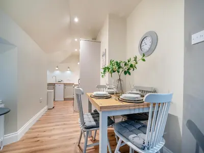 a kitchen and dining room with a table and chairs at North Lodge in Colintraive