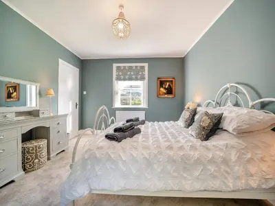 a bedroom with a white bed and a fireplace at North Lodge in Colintraive