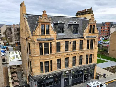 an old brick building on the corner of a street at 6 Smithhills - Sleeps 3 Central Excellent Transport Links Glasgow & Airport in Paisley