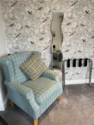 a blue chair in a living room with a wall at Beach room in Ayr