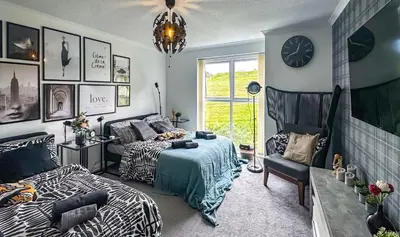 a bedroom with two beds and a couch and a clock at Brand New Scotland home 3rooms near Glasgow in Clydebank