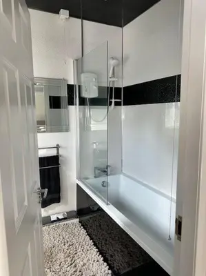 a bathroom with a shower with a glass door at 3 double bedroom spacious flat in Largs