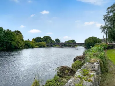 a river with a bridge in the background at Lisset in Newton Stewart