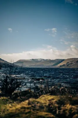 a large body of water with mountains in the background at Loch Earn leisure park in Saint Fillans