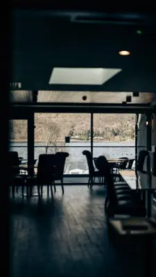 a room with chairs and a view of the water at Loch Earn leisure park in Saint Fillans