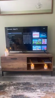 a wooden entertainment center with a flat screen tv at Loch Lomond Riverside Apartments B in Balloch