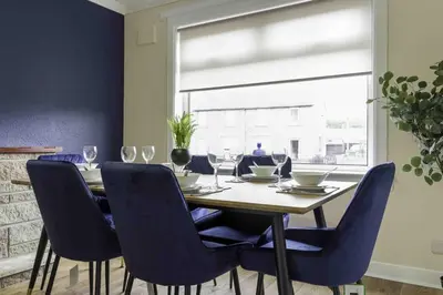 a dining room with a table with chairs and a window at Cochran House in Bathgate