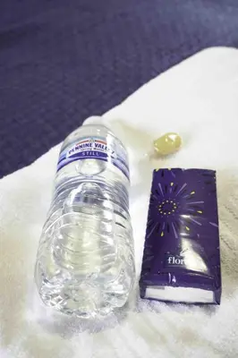 a bottle of water sitting on a table with a gift voucher at Cochran House in Bathgate