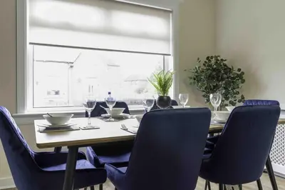 a dining room table with chairs and wine glasses at Cochran House in Bathgate