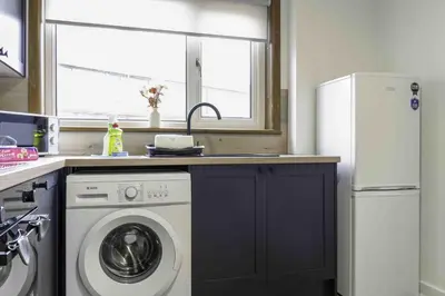 a kitchen with a washing machine and a window at Cochran House in Bathgate