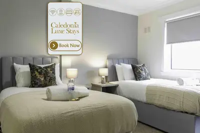 a bedroom with two beds and a sign on the wall at Scotia House in Larkhall