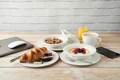 a table with two plates of breakfast food and a laptop at Queen of the Loch, Balloch by Marston's Inns in Balloch
