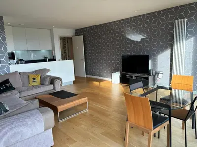 a living room with a couch and a table at Stunning park view Quartermile apartment close proximity to Castle University in Edinburgh