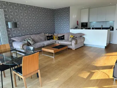 a living room with a couch and a table at Stunning park view Quartermile apartment close proximity to Castle University in Edinburgh