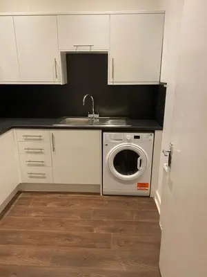 a kitchen with a sink and a washing machine at Central Morrison Street Apartment in Edinburgh