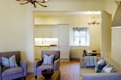 a living room with two chairs and a couch at Luss Cottages at Loch Lomond Arms Hotel in Luss