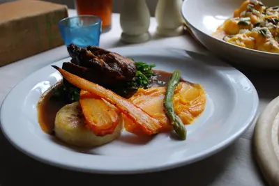 a plate of food with meat and vegetables on a table at The Cross Keys in Kippen in Kippen