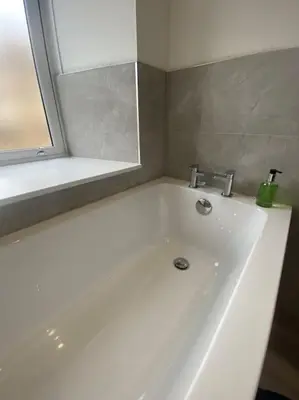a white bath tub with a sink and a mirror at 4 Smithhills Central 2 bed sleeps 4 in Paisley