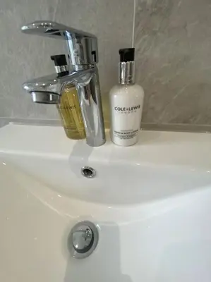 a bathroom sink with a bottle of soap on it at 4 Smithhills Central 2 bed sleeps 4 in Paisley