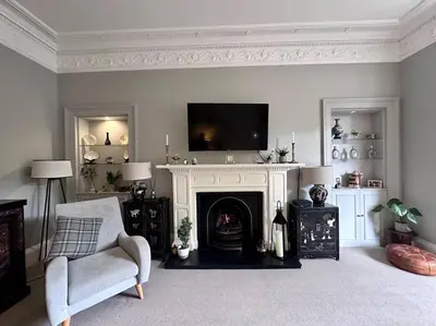 a living room with a fireplace with a tv above it at Stylish Murrayfield sanctuary in Edinburgh