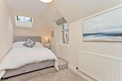 a bedroom with a bed and a painting on the wall at Stylish Murrayfield sanctuary in Edinburgh
