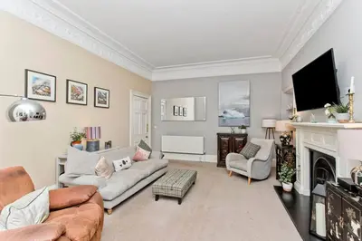 a living room with a couch and a fireplace at Stylish Murrayfield sanctuary in Edinburgh
