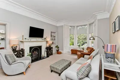 a living room with a couch and a fireplace at Stylish Murrayfield sanctuary in Edinburgh