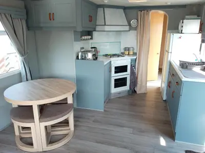 a small kitchen with a table and a stove and refrigerator at Cairnryan - Loch Ryan View in Cairnryan