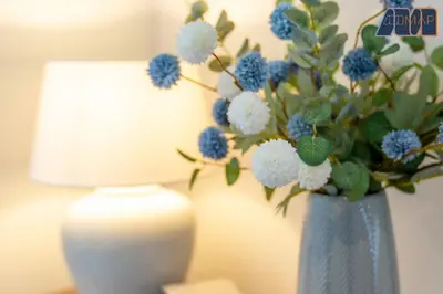 a blue vase with blue and white flowers next to a lamp at Large Family Home with Hot Tub or Jacuzzi, Log Burner in Bearsden