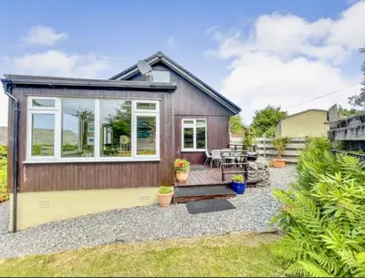 a small house with a patio and a table at Picturesque beauty of Strachur in Strachur