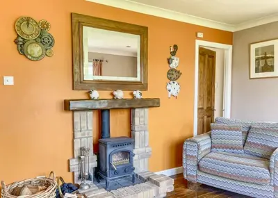 a living room with a fireplace and a mirror at Picturesque beauty of Strachur in Strachur