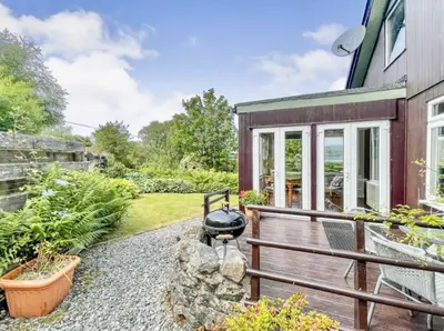 a house with a deck with a grill on it at Picturesque beauty of Strachur in Strachur