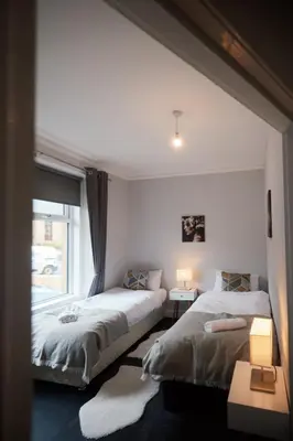two beds in a room with a window at A stunning And Slick Escape in Stonehouse