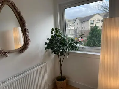 a mirror and a plant in a room with a window at Largs 2 bedroom Apartment in Largs