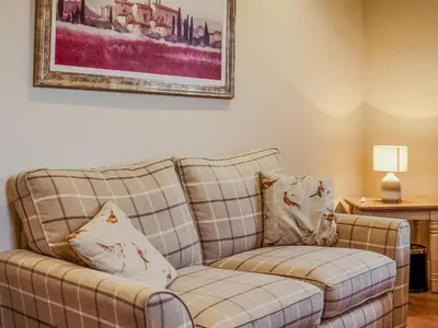 a couch and a chair in a living room at Cairnies - Uk47886 in Keilour