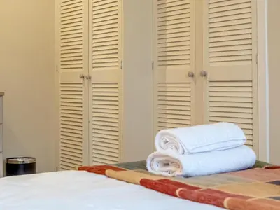 a bedroom with white shutters and towels on a bed at Cairnies - Uk47886 in Keilour