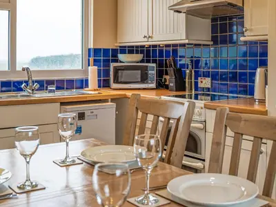 a kitchen with a table with wine glasses on it at Langside - Uk47885 in Keilour