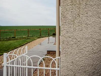 a white fence next to a wall with a field at Lochy - Uk47884 in Keilour