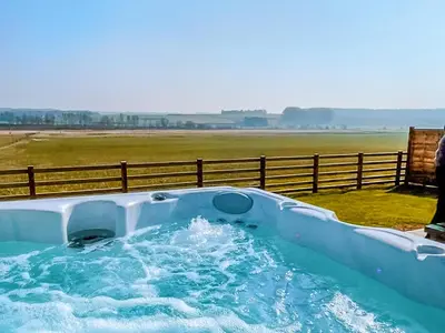 a hot tub in a field with a fence at Timothy Yurt - Uk47889 in Keilour