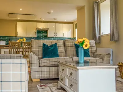 a living room with a couch and a table with flowers on it at Dovecote - Uk47887 in Keilour