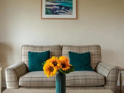 a vase filled with yellow flowers in a living room at Dovecote - Uk47887 in Keilour