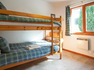 a bedroom with two bunk beds and a window at Bidean Cottage - Uk41933 in Glencoe