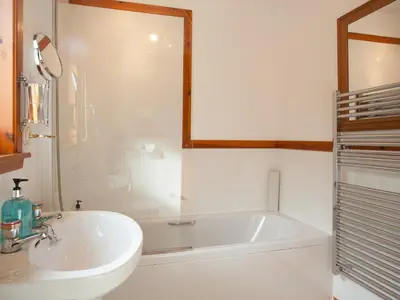 a white bathroom with a tub and a sink at Bidean Cottage - Uk41933 in Glencoe