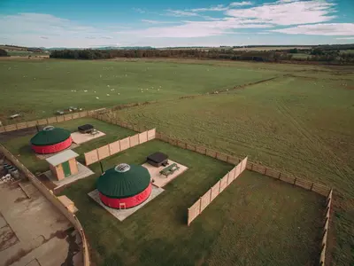 an aerial view of a large field with two domes at Moss Yurt - Uk47888 in Keilour