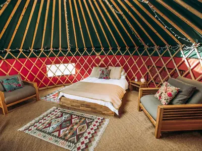 a room with a bed and two chairs in a yurt at Moss Yurt - Uk47888 in Keilour
