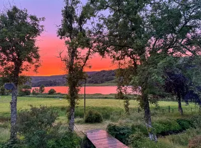 a bench in a field with a sunset in the background at The Coach House Knipoch in Oban