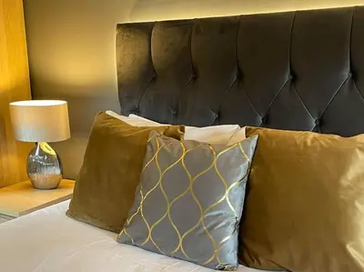 a bed with two pillows and a black headboard at Riverview Lodge & Luxury Hot Tub in Acharra