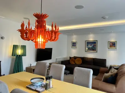 a living room with a table and a chandelier at Crieff Armoury in Crieff
