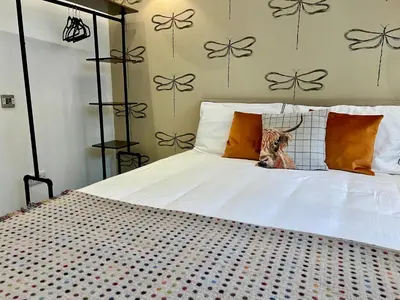 a bed with a deer head sticking out of the pillows at Crieff Armoury in Crieff