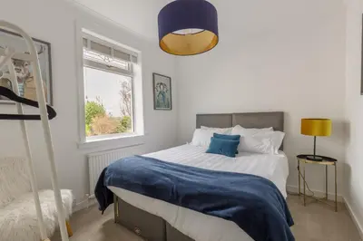 a bedroom with a bed with a blue blanket at The Paddock at Brickrow Farm in Ayr